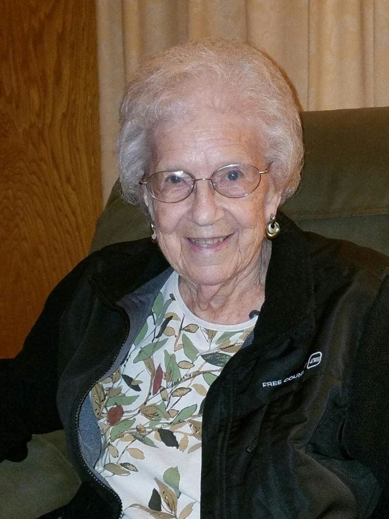 Smiling older woman in glasses, a Roofing 911 Program family